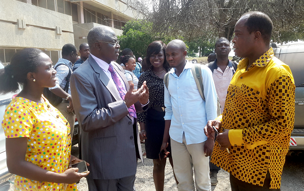 Professor Kuupole (left) interacting with the then Head of Department of the Department of Communication of the University of Cape Coast, Dr Philip Arthur Gborsong (right), while some of the students look on