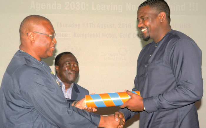 Mr Alex Segbefia (left), the Minister of Health, presenting a scroll of office to Mr John Dumelo, an actor, as a sign of endorsement as Obstetric Fistula ambassador in Ghana. Looking on is Dr Babatunde Ahonsi (partly covered), UNFPA representative. Picture: GABRIEL AHIABOR