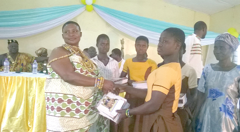  Nana Borfule Okogye presenting exercise books to a schoolgirl. 