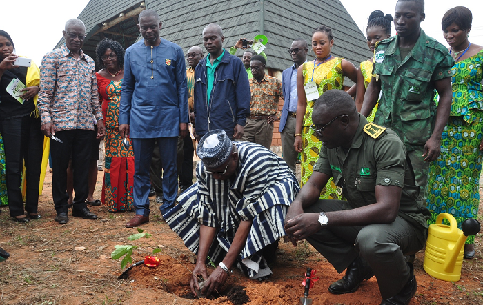  Mr Bugri Tia planting a seedling to symbolise the commencement of the construction of the Accra Eco Park. With him are Nii Osa Mills (2nd left) and Mr Samuel Afari Dartey (squatting)