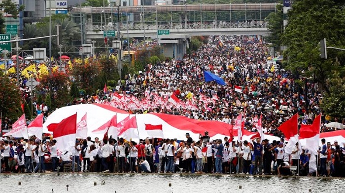 Crowds waved 'We Are Indonesia' signs and held a giant red-and-white national flag [Reuters]
