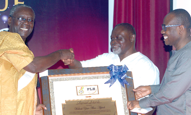 •  Mr Kwesi Nyantakyi (right) being  assisted by boxing legend Azumah Nelson, to present a Certificate of Honour to Mr Abra Appiah, former chairman of the PLB.