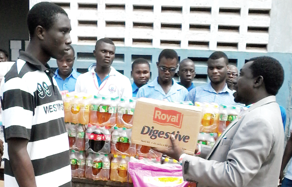 Apostle Appiah presenting the food items to Master Armah