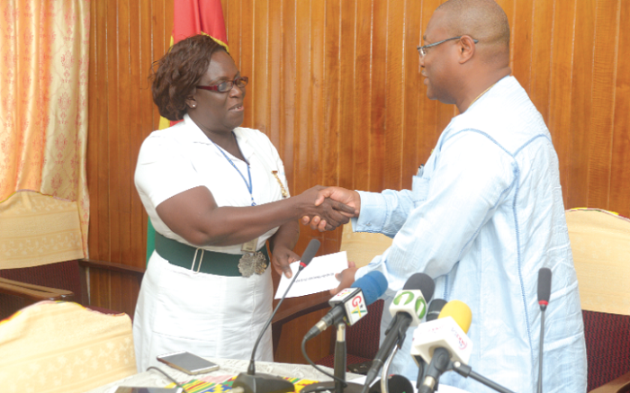 Mrs Dorothy Adelina Daiby Mensah, Principal Nursing Officer of Korle Bu Teaching Hospital, receiving the cheque from Mr Alex Segbefia