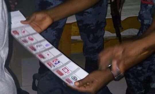 Security officers examining some of the fake ballot papers