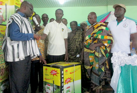 Mr Charles Obeng-Inkoom, MP for Agona West, (left) in a handshake with Mr Kojo Korankye, the Chairman of the Cocoa Farmers Association, after presenting the machines to him