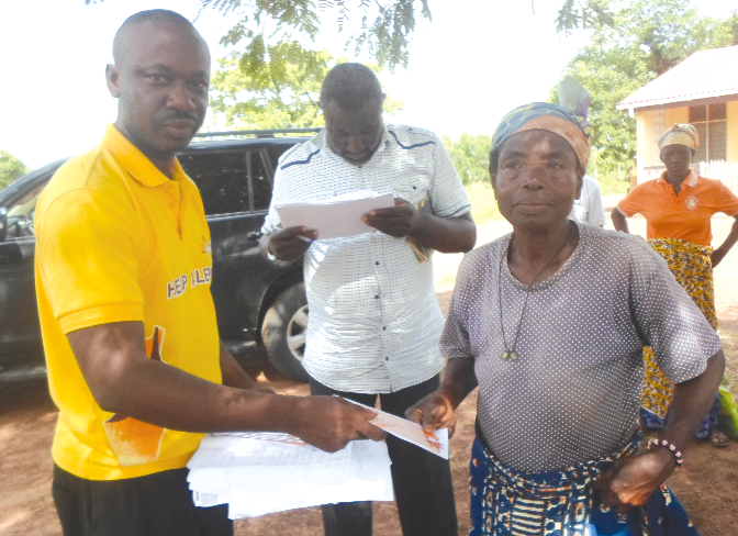 One of the curred lepers receiving her share of the District Assemblies Common Fund from Mr Martin Tandoh (left)