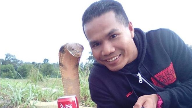 Abu Zarin Hussin takes a selfie with one of his snakes