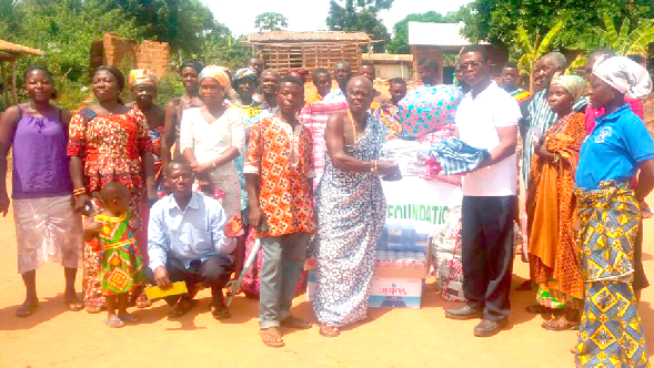 The chairman of Onuapa Foundation, Mr Blessed Ayisi (right) presenting some of the items to Nana Amankrado Kwadwo Okwabi, one of the beneficiaries.