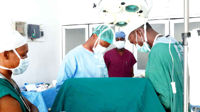 A team of doctors and paramedics performing surgery on a hernia patient