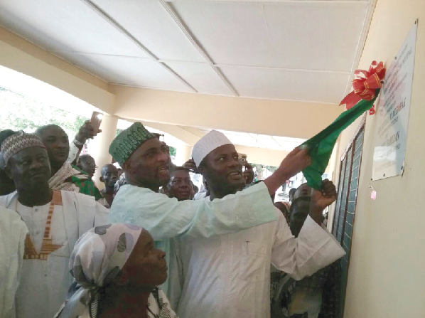 The MP for Asawase, Alhaji Mohammed Muntaka Mubarak (2nd left), being assisted by the MCE for Asokore Mampong, Alhaji Nurudeen Hamidan (right), to unveil a plaque to inaugurate the building.