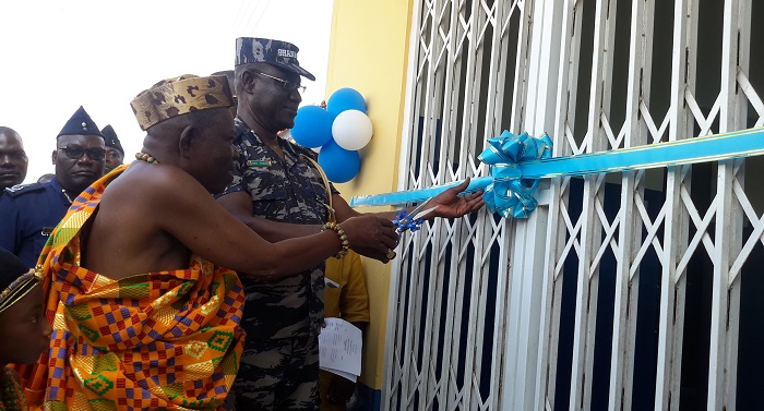 COP Frank Adu-Poku (left) assisting Nana Kwesi Baah II (right), the Chief of Fetteh Kakraba, to cut the tape to officially inaugurate the police post. 