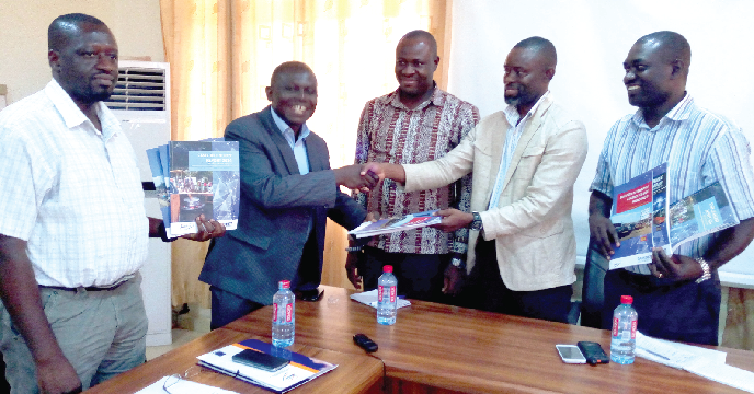 Professor  Felix Ankomah Asante (left) presenting the reports to Mr Laud Binka, Assistant Director of the assembly