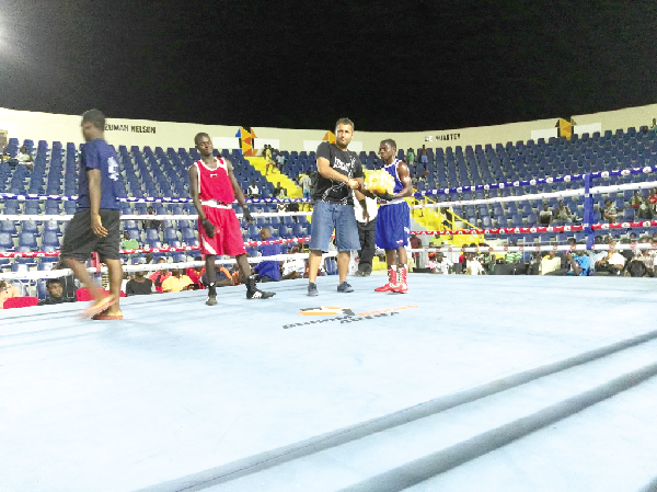 Nellis Dodoo (right) receives a pack of drinks from a member of Polska promotion after defeating Ebenezer Ankrah (far left)