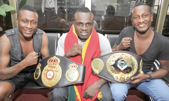 Tagoe (middle) displaying some of his belts