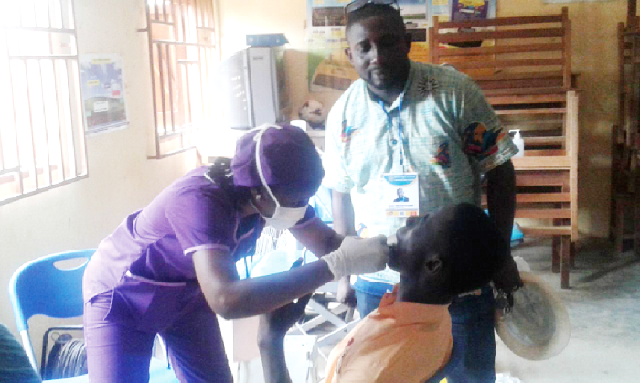  Dr Mabel Delali Azumah (left) attending to one of the pupils during the screening at Esreso with a colleague looking on