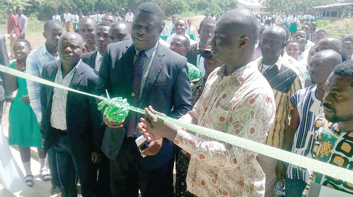  Mr Alex Bonsu (right) cutting the tape to inaugurate the teachers’ bungalow for Manso Adubia SHS