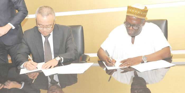   Mr Charles Abugre and Mr Xu Yingxin, Vice-President of China National Textile and Apparel Council appending their signatures to the documents. Picture: EBOW HANSON