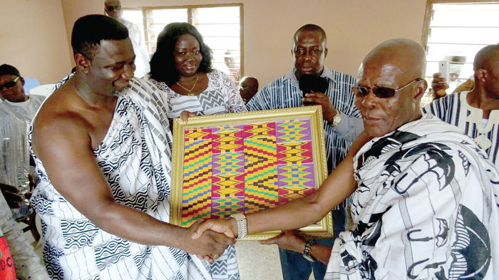  Andy Osei Okrah (left) receiving the gift from Nana Kwakye Berko Dankagyeabour, the Adanwomase Nkosuohene 