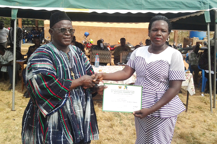 Naba Thomas Azubire, Chief of Vea, presenting an award to Mrs Esther Alangture