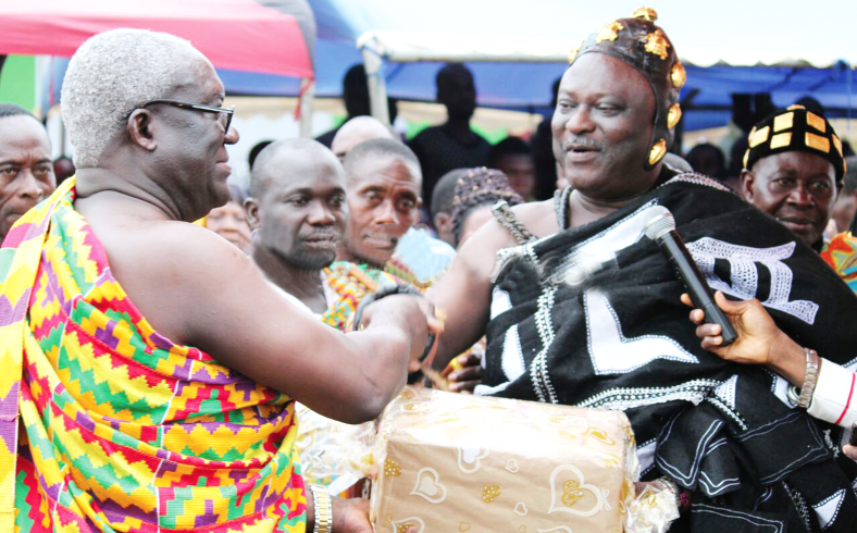 Mr Kofi Asamoah (left) receiving a present from the Suhumhene, Osabarima Ayeh Kofi