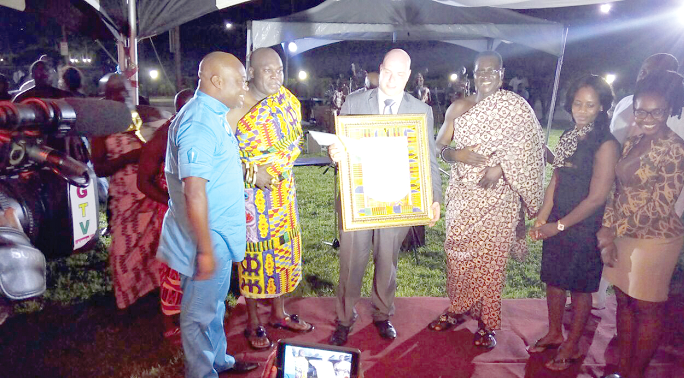 Odeneho Akoto Kwafo III (2nd left), the Paramount Chief of Akwamu Traditional Area, after presenting the citation and memento to Mr Alexandros Zissimatos, the GM of Royal Senchi Hotel and resort. With them is Mr Gideon Aryeequaye (left)