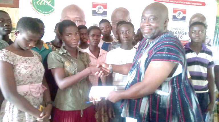 • Nenyi Andah (right) presenting a scholarship letter to one of the beneficiaries