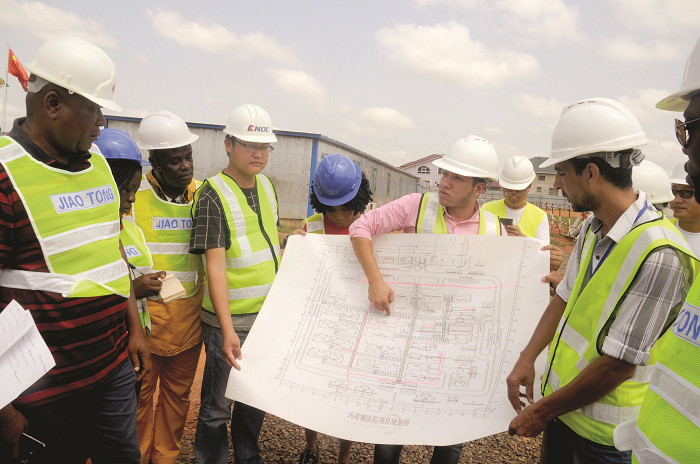  Mr Omar Wahied (pink shirt), Resident Engineer of the project, explaining a point to Mr Baba Anaba (left), Administrator of Euroget, and other officials during a tour of the 100-bed Madina District Hospital under construction