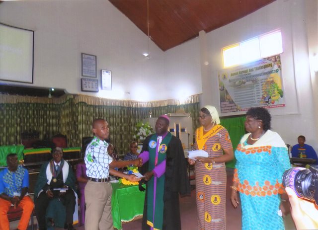 Rt Rev Kwame Baffour-Kyei presenting a package to one of the scholarship beneficiaries