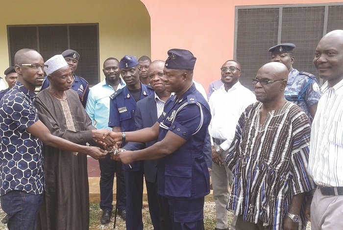Alhaji Braimah Boyong (2nd left), the MCE, handing over the keys to the building to Supt Bossman while the presiding member and other ofiicials look on. INSET: The front view of the new police quarters at Konongo