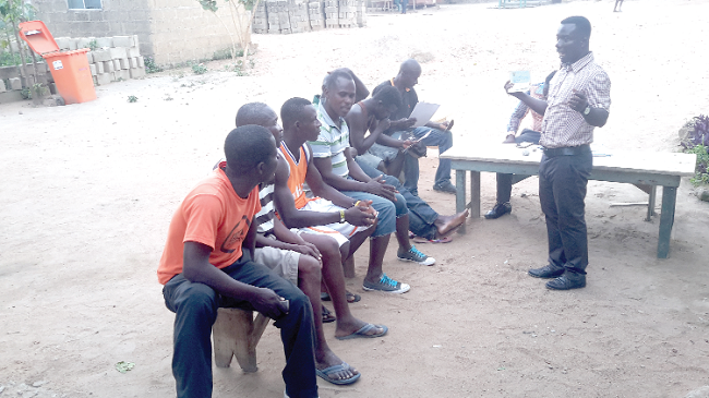 Mr Innocent Donkor explaining a point to young men at Top Town Apeedwa