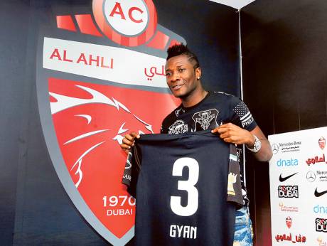 Asamoah Gyan shows off his Al Ahli team jersey at a media conference in Dubai on Sunday.