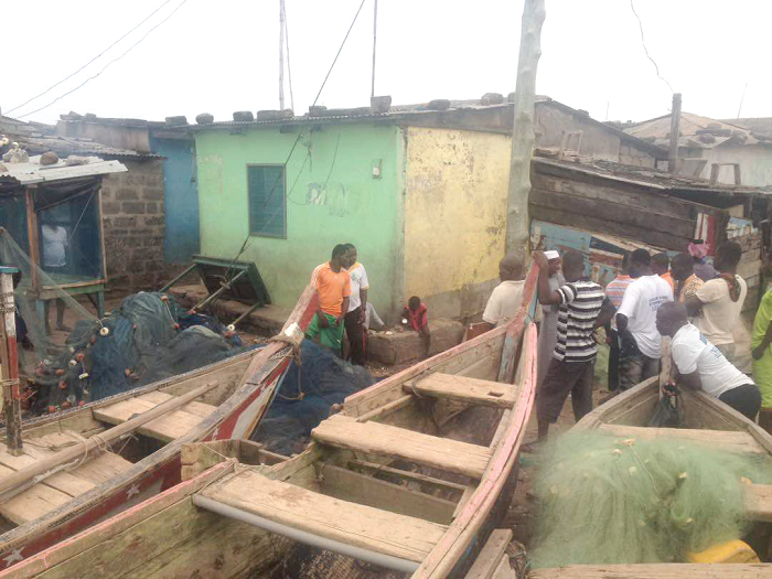 Some fisherfolk in the Aboadze community assessing the extent of damage caused by the waves