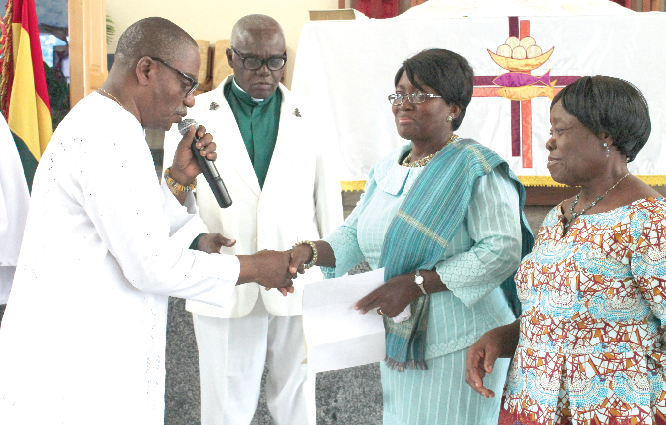 Prof Lorna Awo Renner (2nd right), Head of the Department of Child Health, Korle-Bu, receiving the cash from Mr Abeeku Arthur (left), Steward of the Immanuel Society of the Methodist Church. Looking on is Very Rev John K Appiah-Acheampong (2nd left), Superintendent Minister of the East Airport Circuit. Picture: Maxwell Ocloo