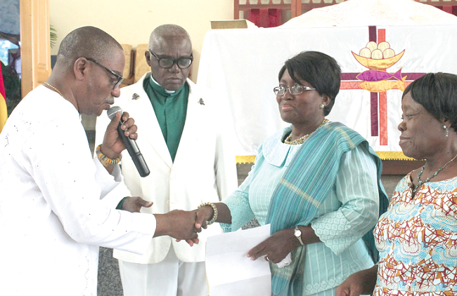 Prof Lorna Awo Renner (2nd right), Head of the Department of Child Health, Korle-Bu, receiving the cash from Mr Abeeku Arthur (left), Steward of the Immanuel Society of the Methodist Church