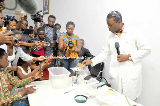 Mr Cheetam Mingle demonstrating the testing of genuine and fake rice at the press conference. Picture: EMMANUEL QUAYE 