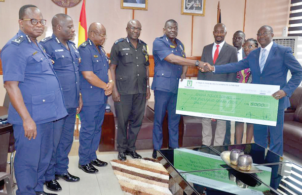 Mr Obeng-Adiyiah (right) presenting the dummy cheque to the IGP