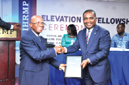 Mr Daniel Aseidu, Managing Director of Agricultural Development Bank (right), receiving his citation as Honorary Fellow of IHRMP from the Chairman of the Fellows Status Committee, Mr John Mbroh