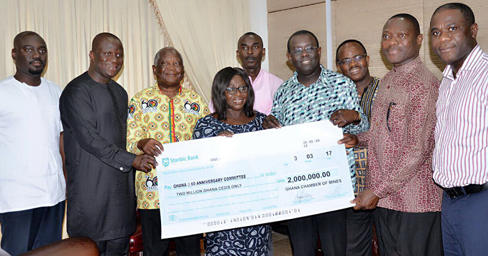 Mrs Frema Osei Opare, the Chief of Staff, receiving a dummy cheque from the Ghana Chamber of Mines