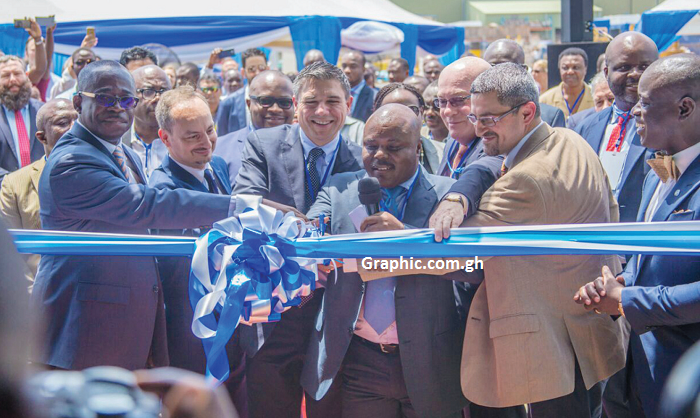  Mr Joseph Cudjoe, the Deputy Energy Minister designate,  being assisted by Lorenzo Simonelli, President and CEO - GE  Oil and Gas Global, to cut the tape to inaugurate the facility