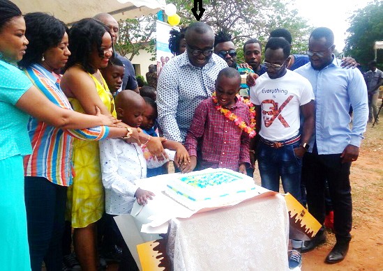 Bola Ray (arrowed) cutting the cake
