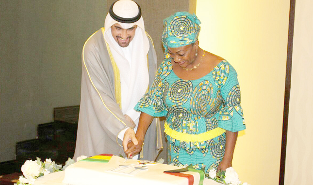 Mr Al-Failakawi being assisted by Ms Djaba to cut the anniversary cake for the 56th National Day of the State of Kuwait