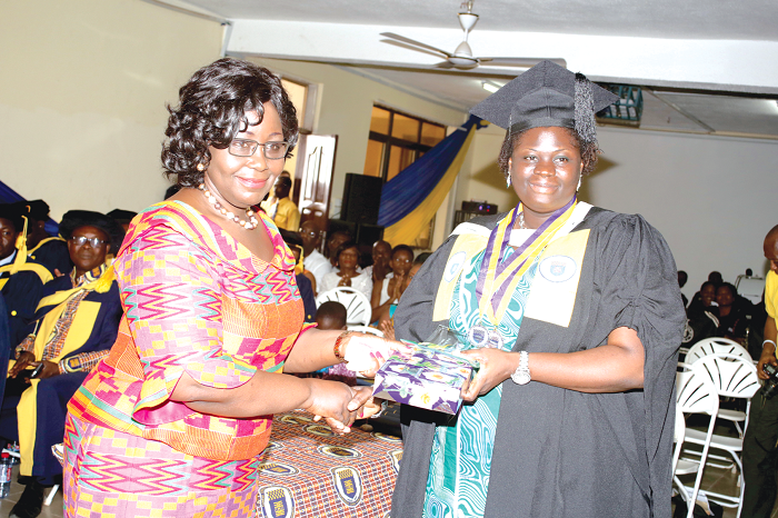  Reverend Patricia Sappor (left), President of the Chartered Institute of Bankers, Ghana, presenting a parcel to Ms Hamdia Amidu Koriwie, who was adjudged the overall best student at the 17th  congregation ceremony of the  Ghana Telecom University in Accra