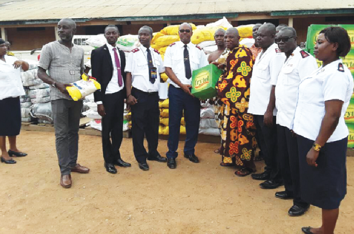 Lt Col. Samuel Kyeremeh (4th left) presenting some items to Nana Odum VII, Gyantoahene of Agona Nyakrom Traditional Council, who received the items on behalf of the flood victims