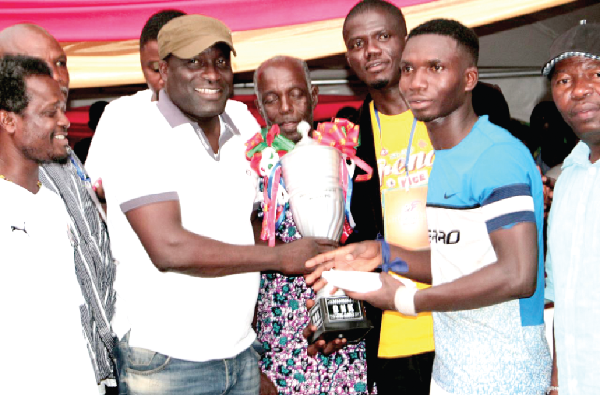 • Captain of Site a, Daniel Nyanteh receiving the trophy from the Member of Parliament for Tema East, Titus Glover