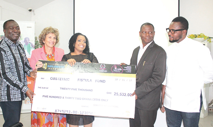 Mrs Suzain Dodoo (3rd left) being supported by Mrs Claudia Turbay Quintero (2nd left) and Dr Babatunde Ahonsi (left), to hand over a dummy cheque to Dr Patrick Aboagye, Director, Family Health Division, while Mr Dodoo looks on. Picture: BENEDICT OBUOBI