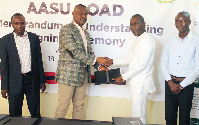  Mr Bonavent Aguissi (2nd left), and Mr Peter Kwasi Kodjie, exchanging documents after the signing ceremony. Those with them are Mr Ansumana B. Bojang (right), Secretary for Press and Information, AASU and Mr Abass A. Sidiki (left), Finance and Administration Officer, OAD. Picture: EDNA ADU-SERWAA