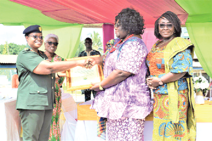 • Prof. Henrietta Mensah-Bonsu (2nd right), Snr lecturer, University of Ghana law faculty, being assisted by Ms Gomashie to present the citation to Brigadier-General Edjeani-Afenu at the event, while Madam Baku (grey haired) looks on. Picture: DELLA RUSSEL OCLOO