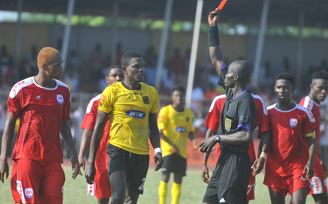 Referee Prince Amoah flashing the red card at Kotoko's Evans Quao and Inter Allies’ Isaac Osae (left) the red card for fighting during the match