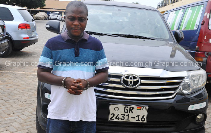Nene Tetteh in front of one of the vehicles